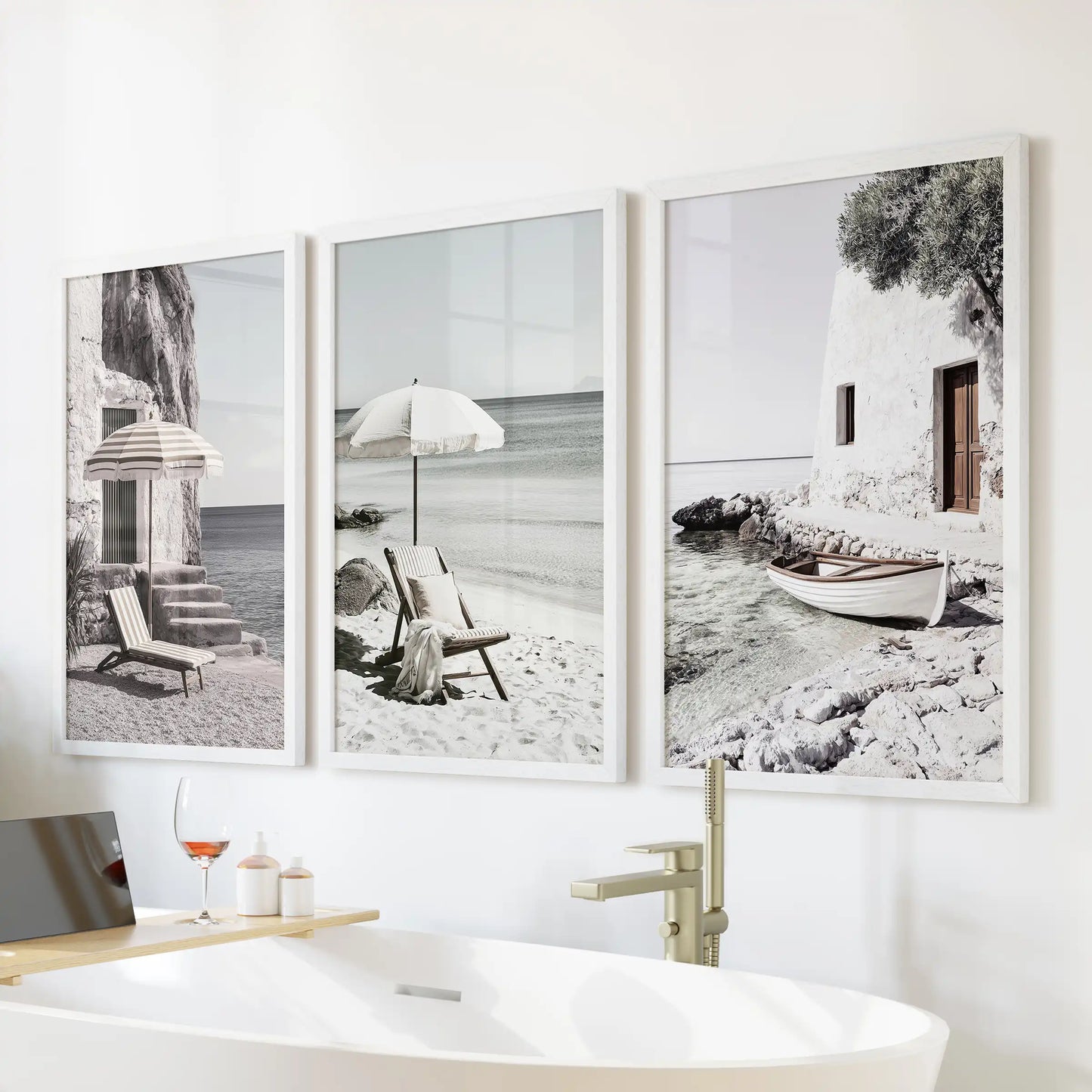 Beach umbrellas on a Greek shore, a trio of wall art in white frames, floating over the bath to freshen the bathroom with breezy Mediterranean ease.