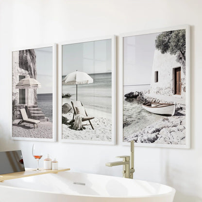 Beach umbrellas on a Greek shore, a trio of wall art in white frames, floating over the bath to freshen the bathroom with breezy Mediterranean ease.