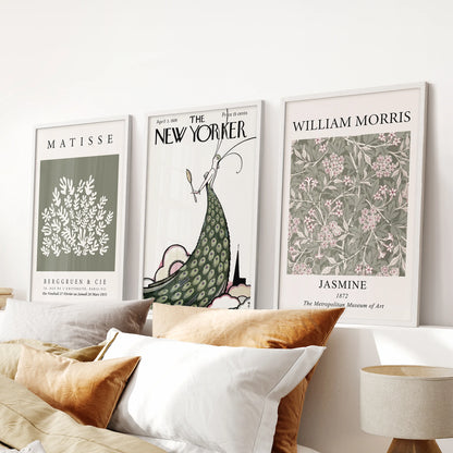 William Morris botanical patterns in a three-piece print set sit in white frames, perfect as wall art above the bed in a calm bedroom.