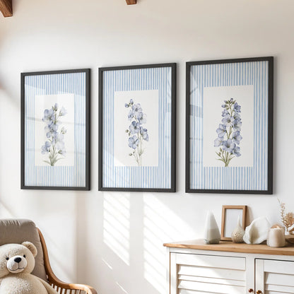 Set of three pastel botanical wall prints in black frames, arranged over a chest of drawers in a children's room.
