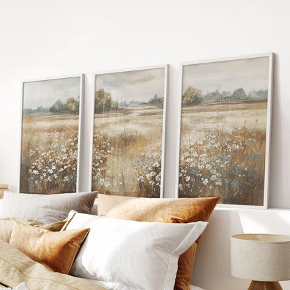 Pastoral meadow triptych, a three-piece wall art set in white frames, rests above the bedroom headboard and brings airy, neutral texture.
