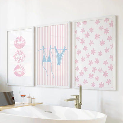 Preppy seaside prints, a three-piece wall art set, sit above the soaking tub in bright white frames to lighten a serene bathroom space.
