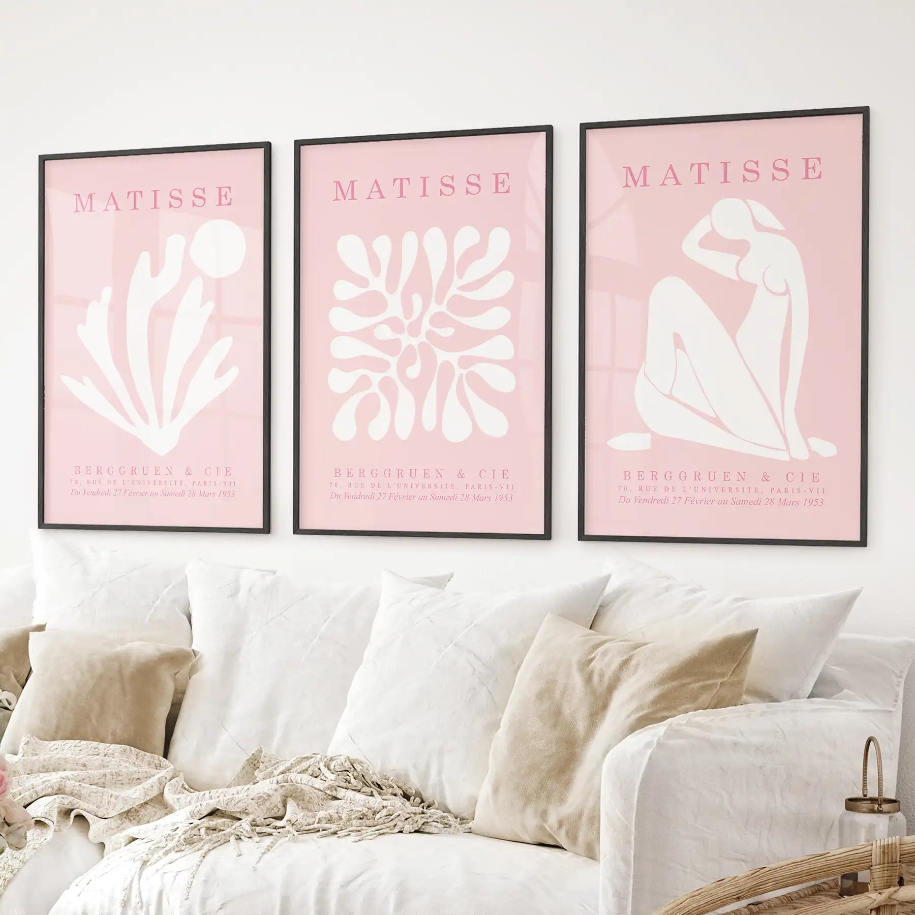 Pink Matisse wall art set of 3 with abstract line drawings and shapes. Black frames above the sofa.