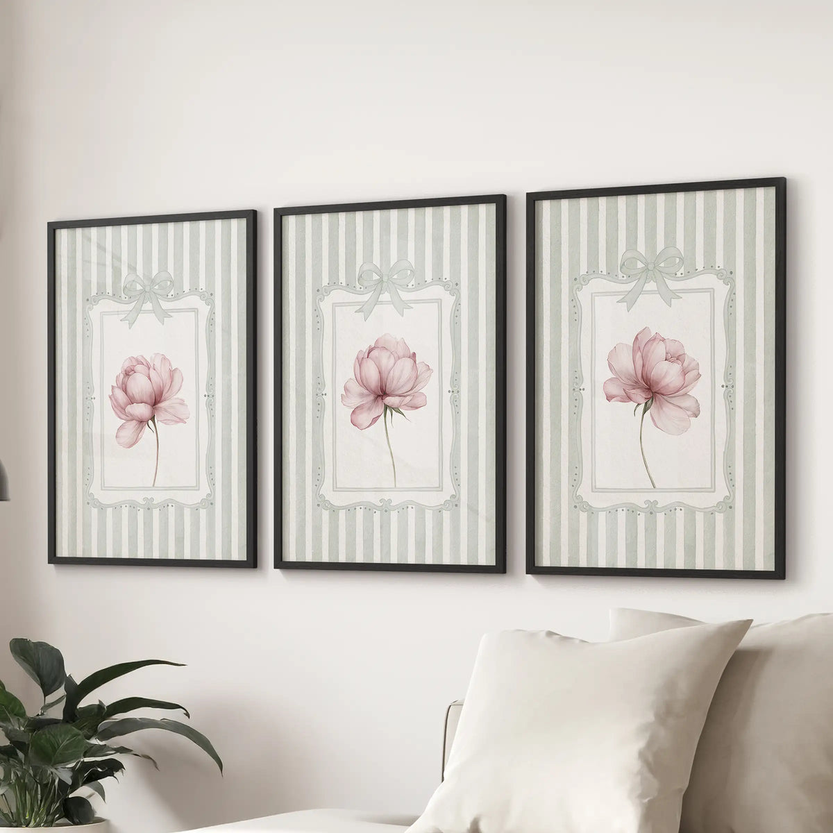 Three-piece pink peony wall art set in black frames, with sage green striped backgrounds, displayed over a sitting room sectional.