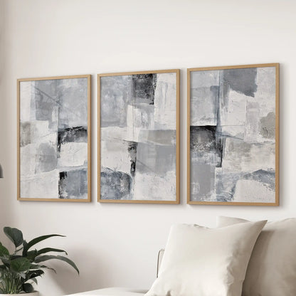 Plaster-effect minimal art wall art in three pieces, set in natural wood frames, spans the wall over the sectional to soften the sitting room.