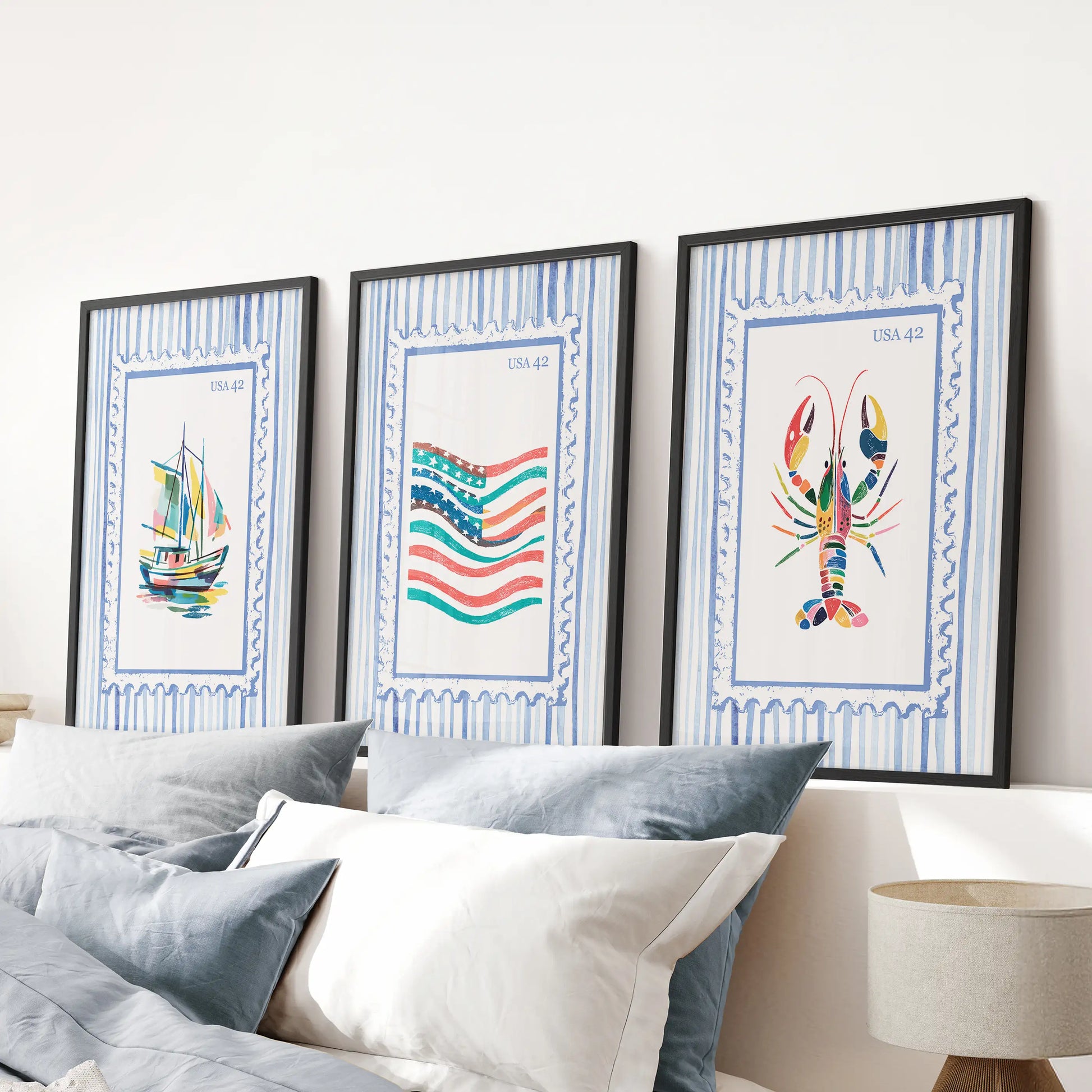 Bright coastal scenes in a wall art triptych, finished with black frames and hung over the bed’s headboard to anchor a serene blue bedroom.