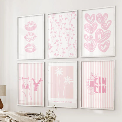 Six white-framed wall prints with pink lips graphics hang beside the bed, giving the airy bedroom a light, playful seaside mood.