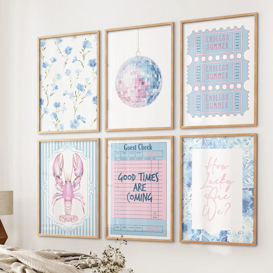 Ticket-style summer posters, a 6-piece collection in oak wood frames, styled beside the bed to channel a sun-soaked, coastal gallery look.
