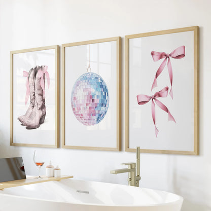 Preppy cowgirl wall art set of three, oak-framed and styled above the tub, gives the bathroom a chic coastal twist in soft pink and powder blue.
