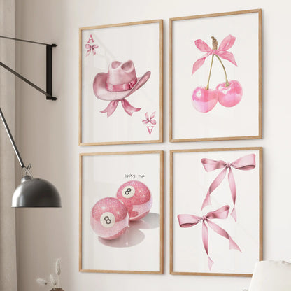 Group of four Ace playing card art prints in warm oak frames, set behind a sofa in a calm, preppy pink sitting room.