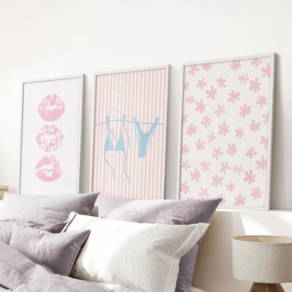 Pastel pink and blue coastal scenes, a three-print wall art set in white-framed prints, sweeten the pink bedroom above the bed.
