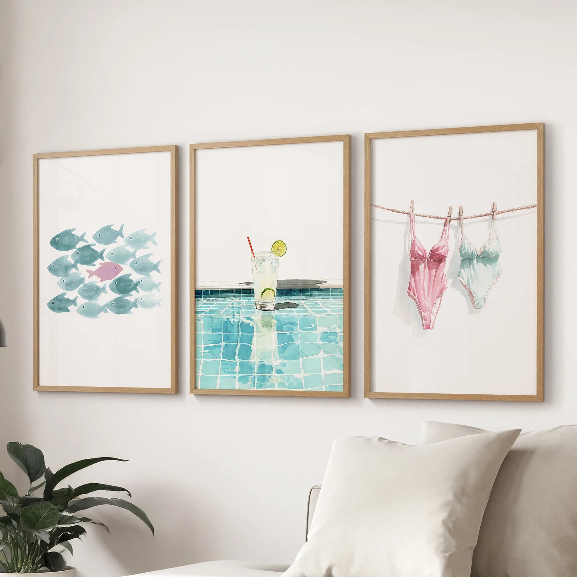 Vibrant summer art poster trio in natural wood frames, mounted above the living room sofa as cheerful wall art with preppy color and summer energy.