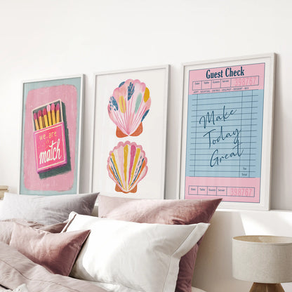 Sleek white-framed prints, a bright trio of playful posters, line the pink bedroom wall above the bed for a fun Y2K touch.