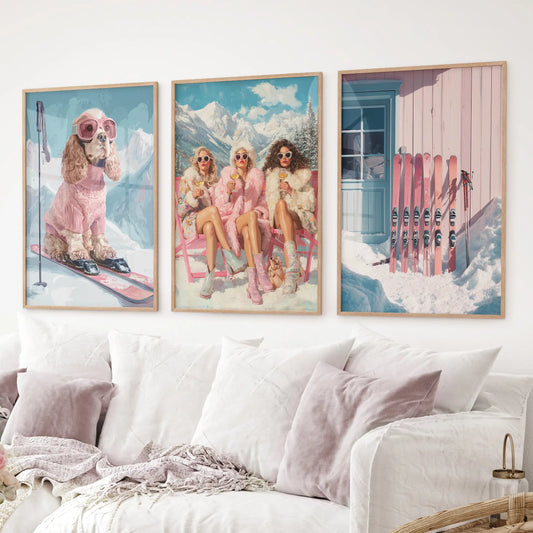 Ski wall art set of 3 featuring dog in pink ski gear, glamorous ski girls, and cabin with pink skis. Thinwood frame over the couch.
