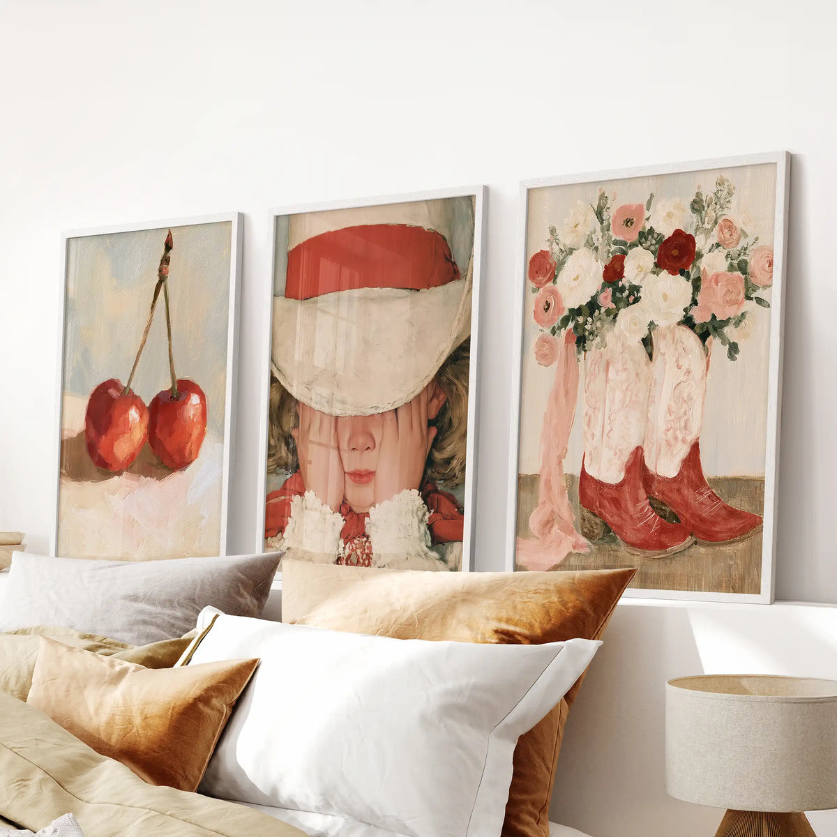 Floral cowgirl boots appear across three artwork prints in white frames, aligned cleanly over the bedroom headboard.