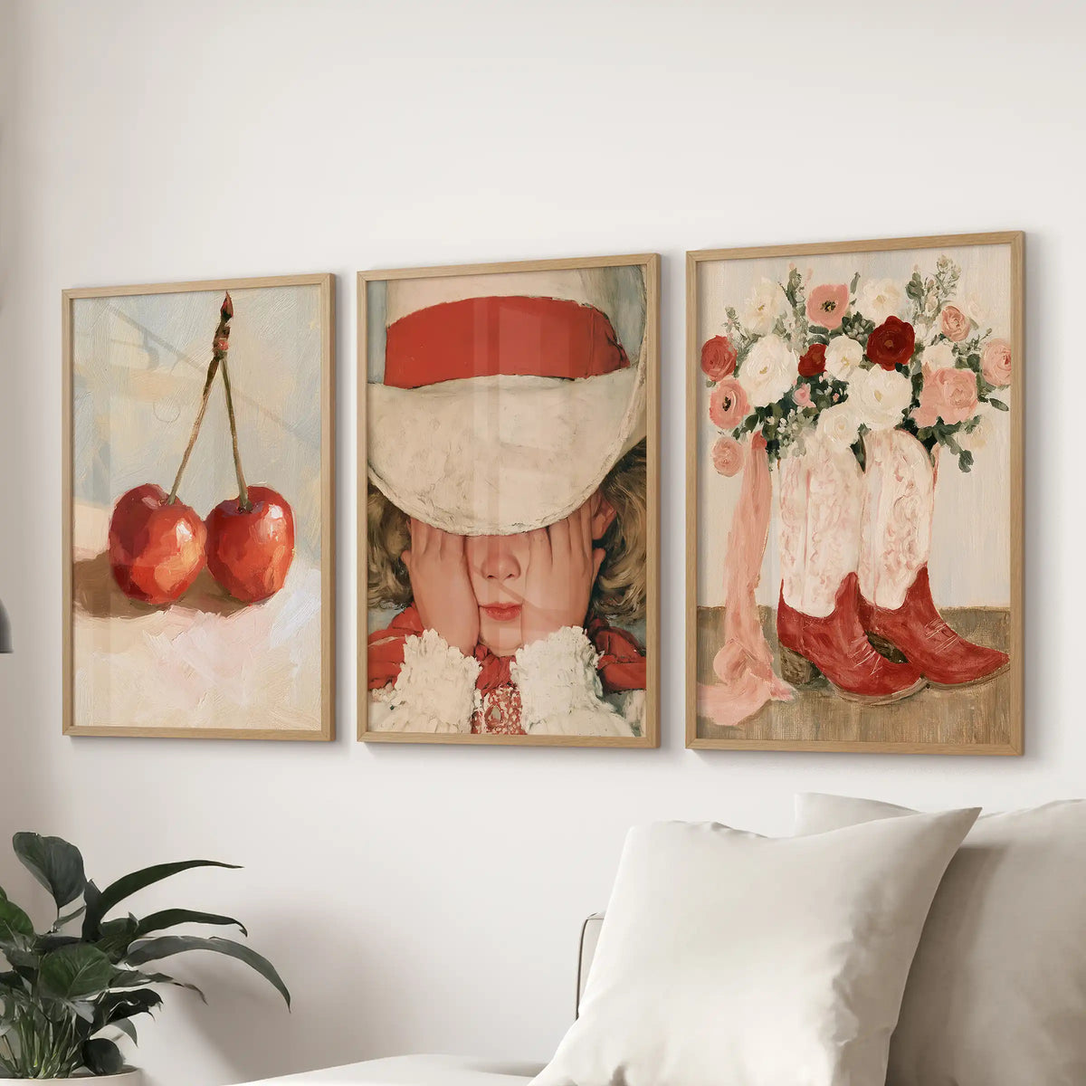 Three vintage floral botanical prints form a gallery wall in wooden frames, neatly aligned over the couch in the living room.