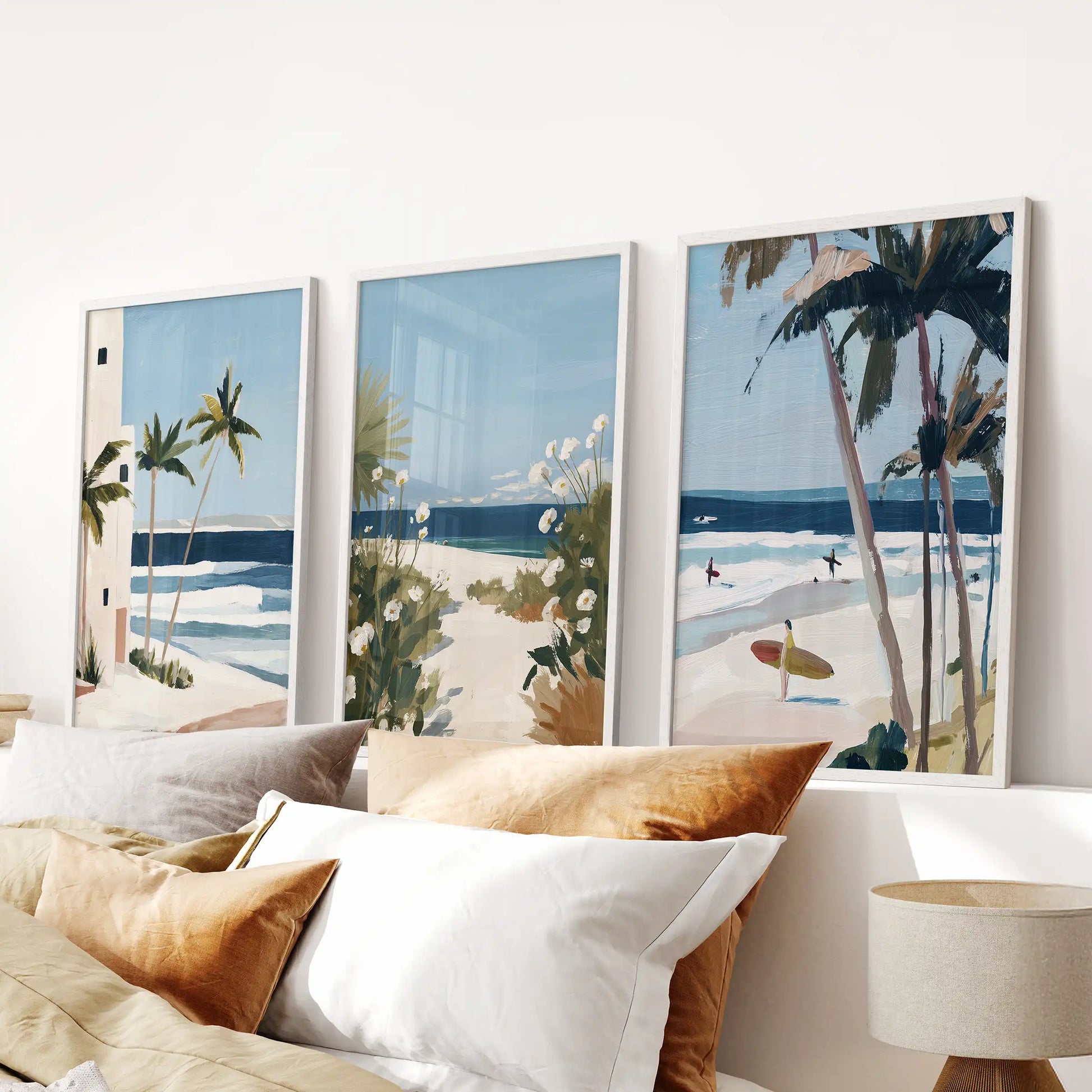 Three white-framed surf-wave artworks ripple gently above the bed, giving the bedroom a soft mix of ocean blues and calm white foam.