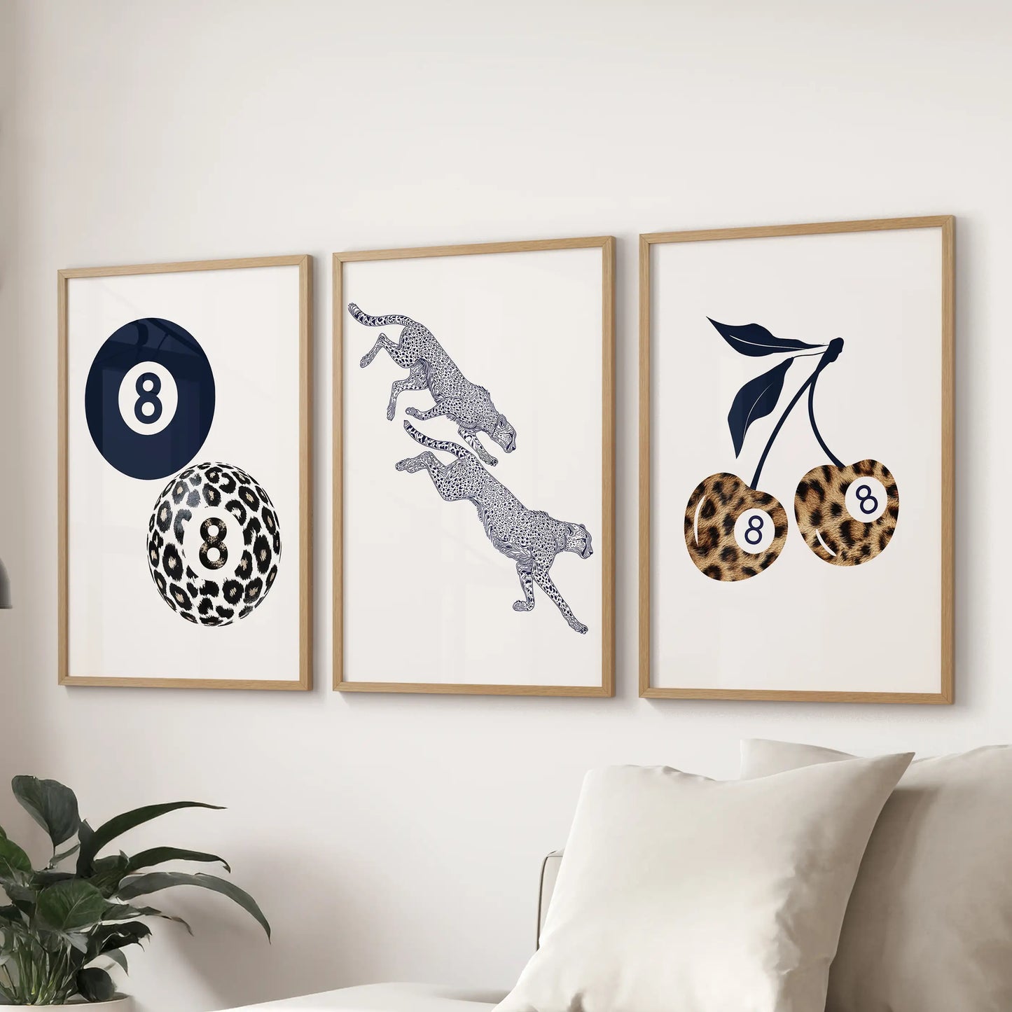 Wood-framed wall art set of three featuring retro navy leopard, cherry, and eight-ball designs brings lively color above the sofa.