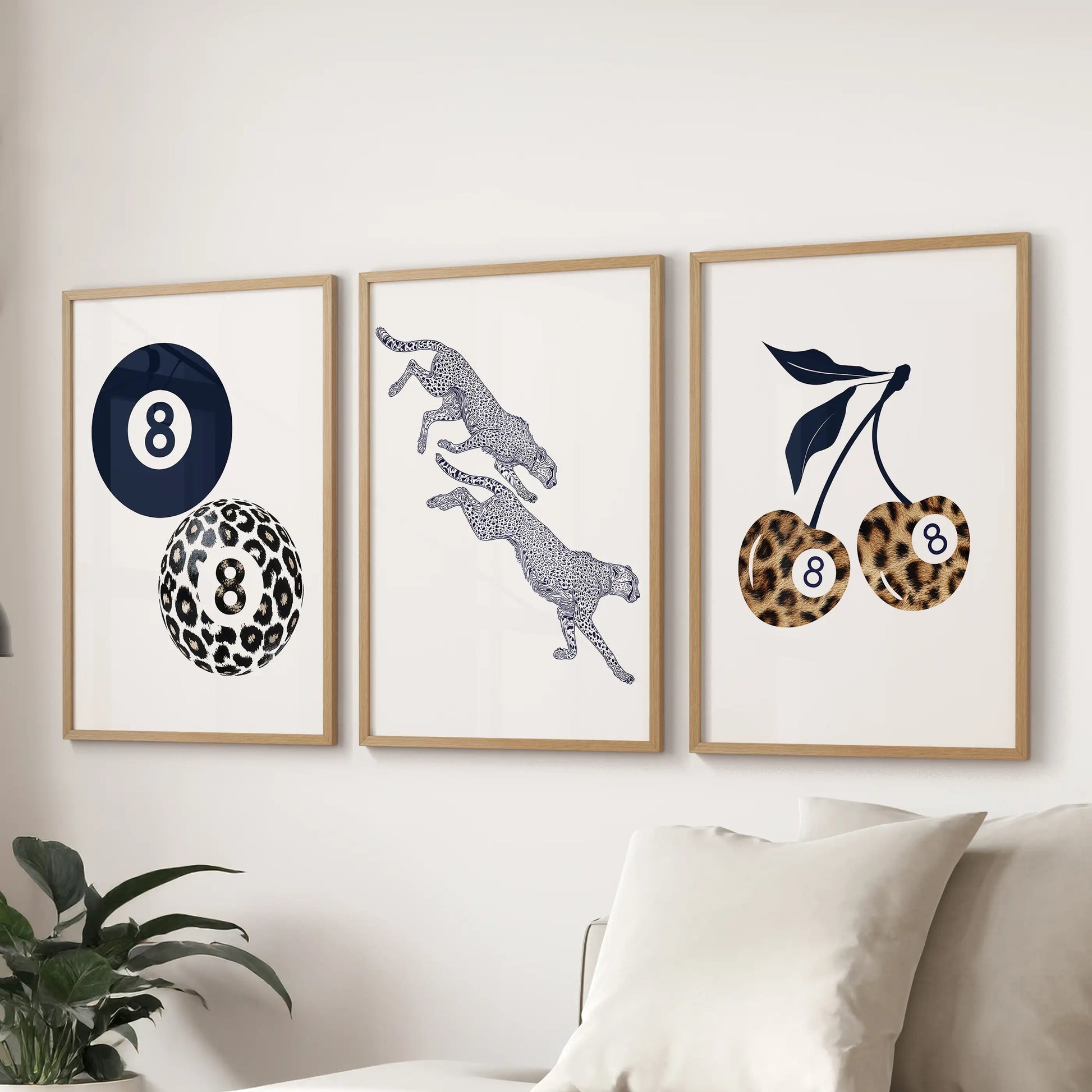 Wood-framed wall art set of three featuring retro navy leopard, cherry, and eight-ball designs brings lively color above the sofa.