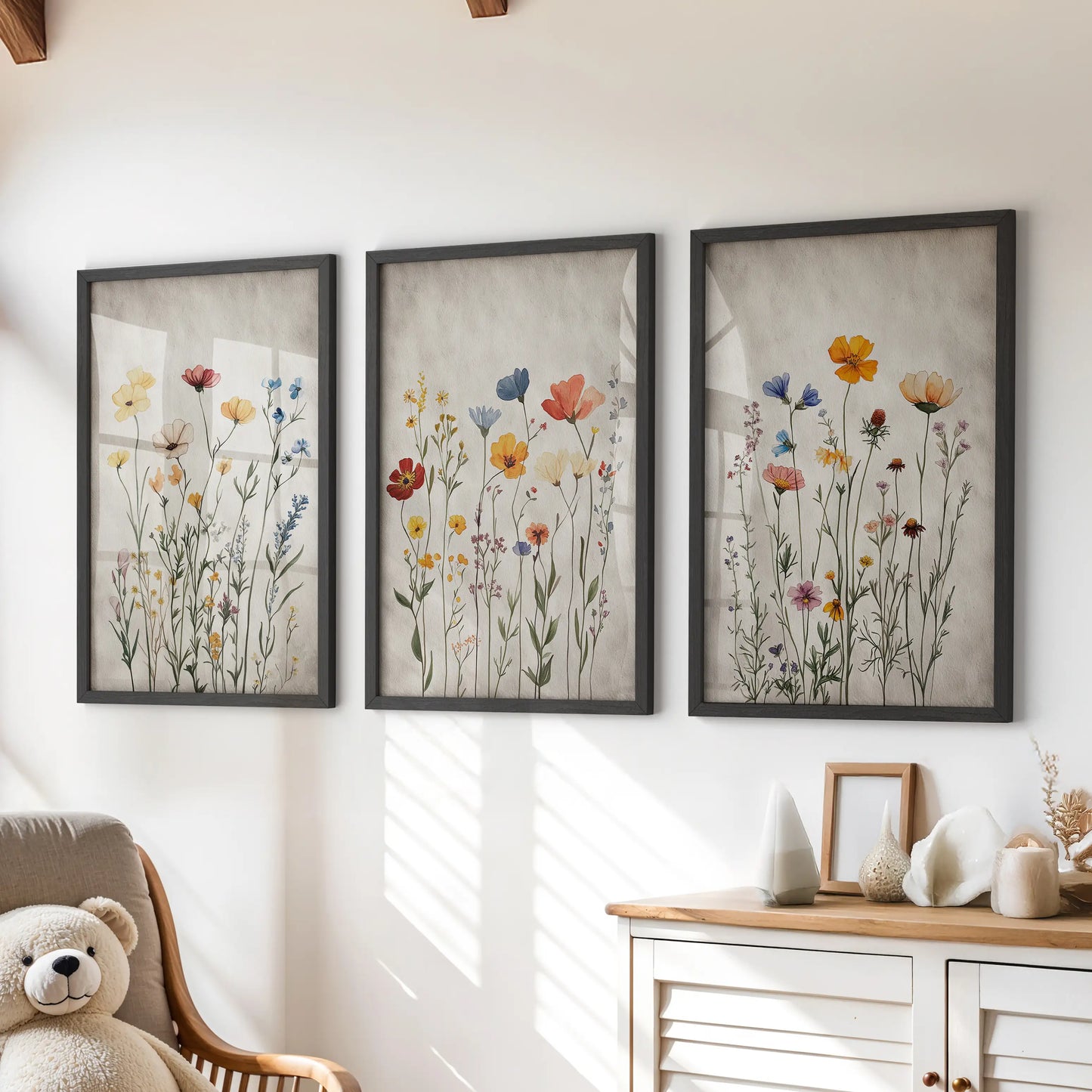 Boho floral prints, a three-print wall art set in black frames, styled to hang over the dresser in a cheerful kids playroom.