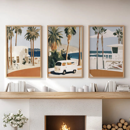 Warm-toned wooden frames hold three retro lifeguard tower prints, giving the lounge fireplace mantel a laid-back coastal note.