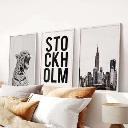 Retro magazine-inspired prints, a set of three posters in crisp white frames, hung above the bed to give a minimalist bedroom a curated edge.