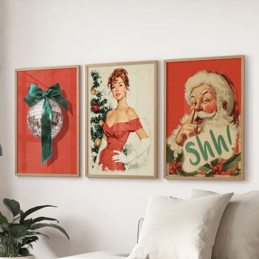 A set of three retro Santa and disco ball art prints in oak wood frames anchors the lounge wall over the couch, adding cozy sparkle and holiday flair.
