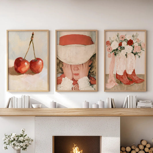A set of three vintage girl wall art prints in natural wood frames brings a soft, romantic touch to the living room above the fireplace.