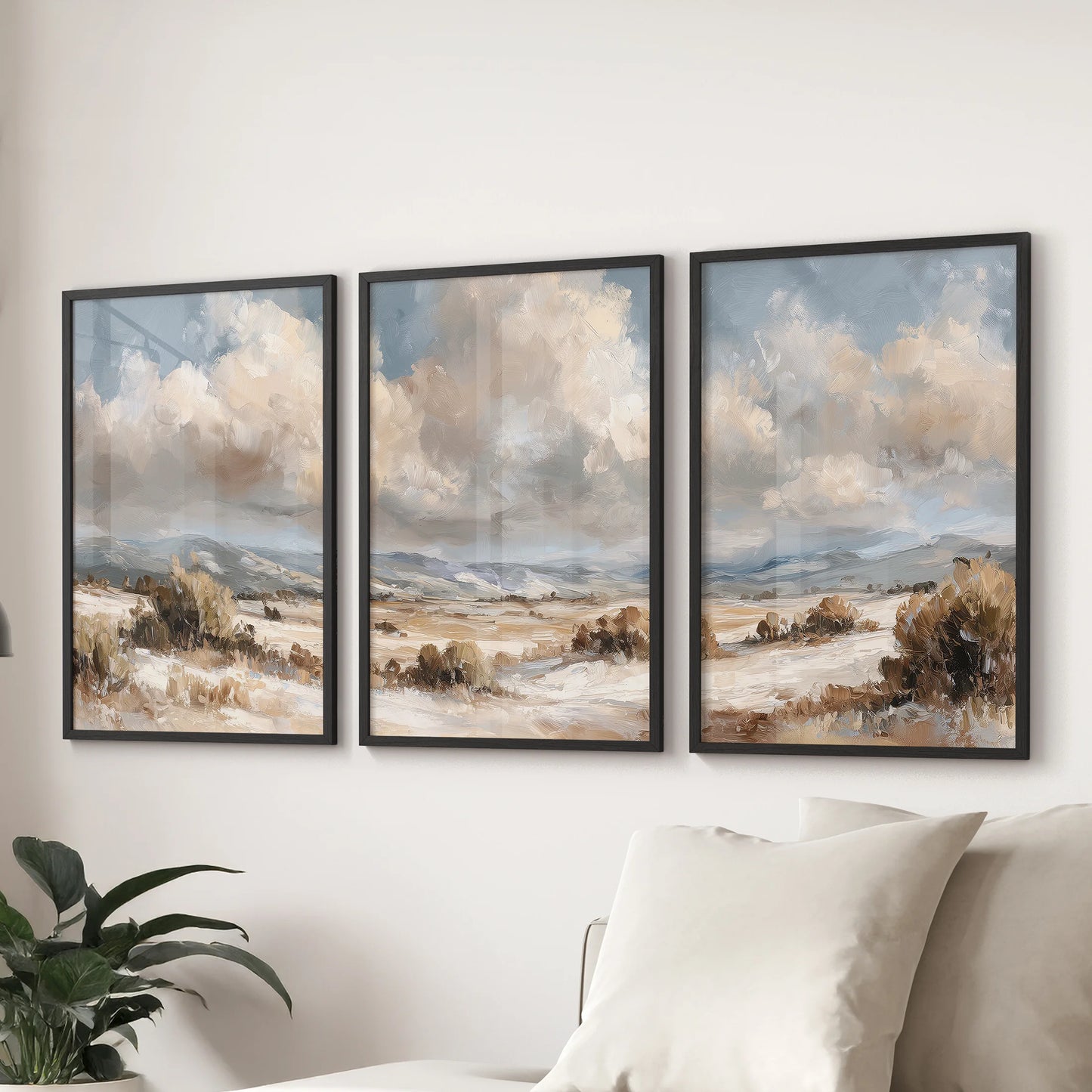 Countryside landscapes in a three-piece wall art set, framed in black, anchor a family room with vintage tones, arranged as a trio behind the sofa.