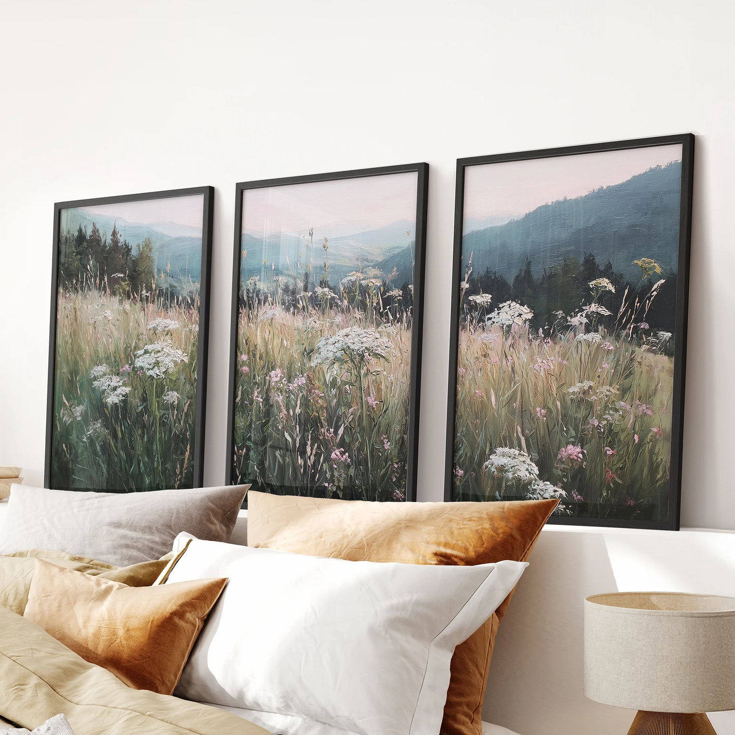 Wildflower meadow landscape wall art set of 3 in black frames creates a gentle focal point over the bed headboard in the bedroom.