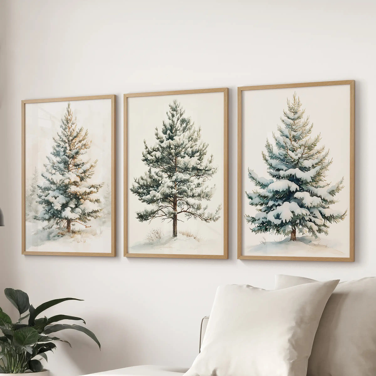 Three-piece wall poster set featuring snowy evergreens in oak frames, displayed above a sitting room sectional.