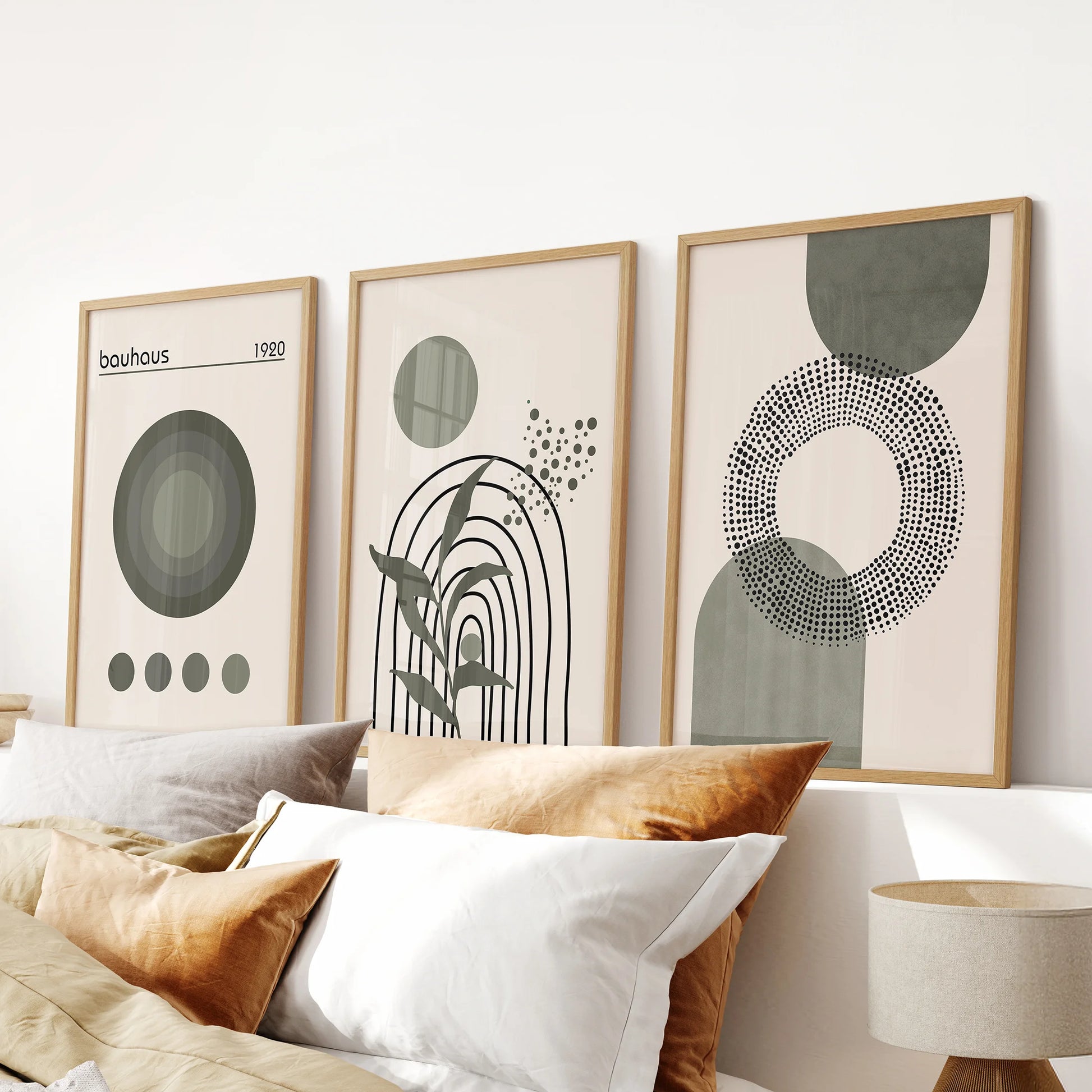 Minimalist green shapes triptych in oak frames, three-piece artwork for the bedroom, sits neatly over the headboard with a warm modern feel.