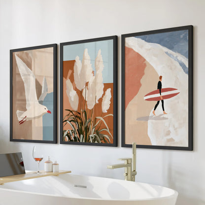 Seagull in flight, 3-piece wall art set in black frames, hangs over the bathtub to bring airy coastal calm to the bathroom with terracotta beach notes.