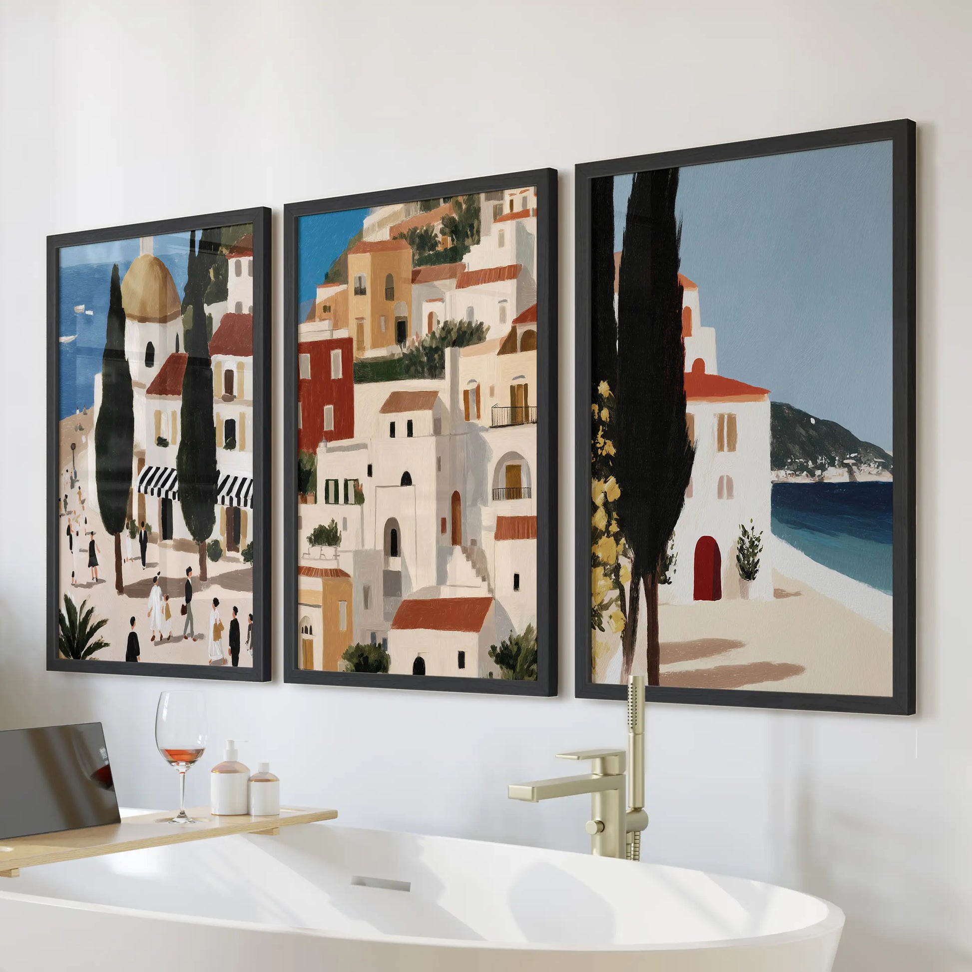 Three black-framed Andalusia travel prints form a wall art trio above the bathtub, filling the bathroom with easy, Mediterranean calm.