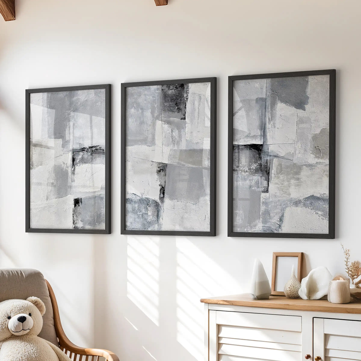 Three plaster-effect minimal art prints in black frames hang above the playroom chest of drawers, adding quiet texture without visual noise.