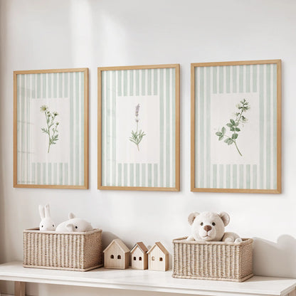 Striped floral wall art in a three-piece print set hangs in thin wood frames over a toy organizer in a kids playroom.