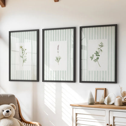 Striped floral wall art in a set of three black framed prints hangs above a dresser in a kids room.