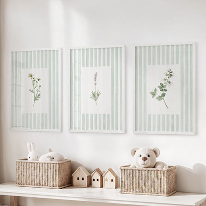 Three striped floral wall art prints in white frames hang above a toy storage bench in a kids room.