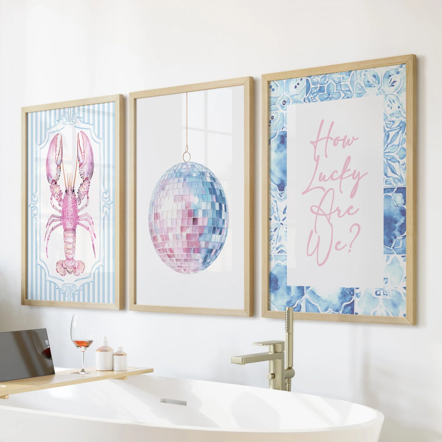 Lobster art three-print set in slim wood frames rests above the soaking tub, a cheeky seaside accent that brightens the bathroom wall.