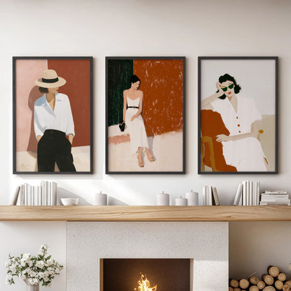 Relaxed summer travel scenes with women, a set of three art prints, rest above the mantel in the sitting room within sleek black frames.