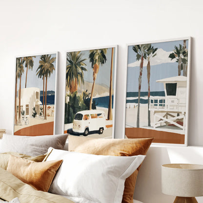 White-framed wall prints of the Laguna Beach coastline form a calming trio above the bed, softening the bedroom’s headboard area.