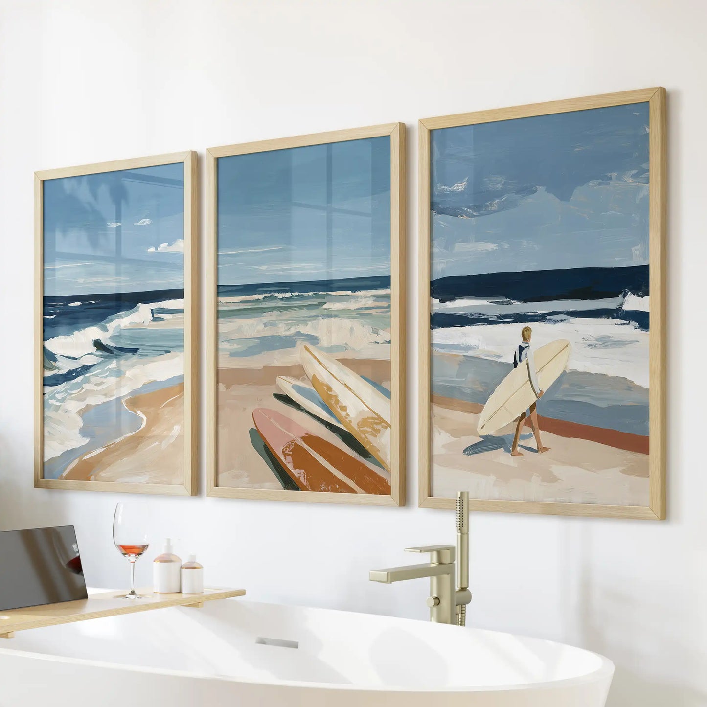 Coastal surf seascapes wall art, a three-piece set in light wood frames, hangs above the bathtub to warm the bathroom with sunlit, watery blues.