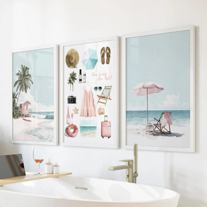 Beach house poster trio in white frames brightens the bath wall, bringing relaxed summer color above the tub.