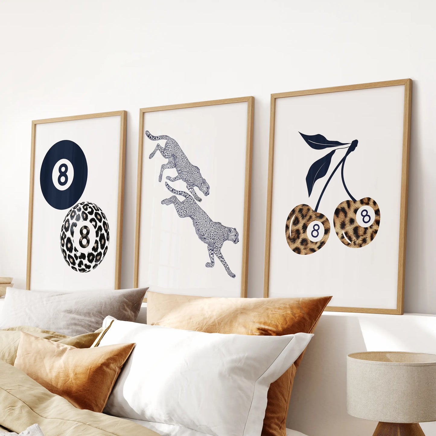 Navy blue cheetah prints, a three-print set in warm oak frames, deliver a sleek statement in the bedroom over the bed.