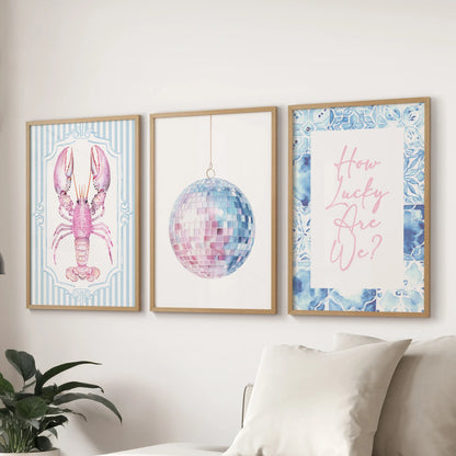 Three coastal prints in thin wood frames line the wall above the couch, blending blue-pink hues for a light and softly beachy living room look.
