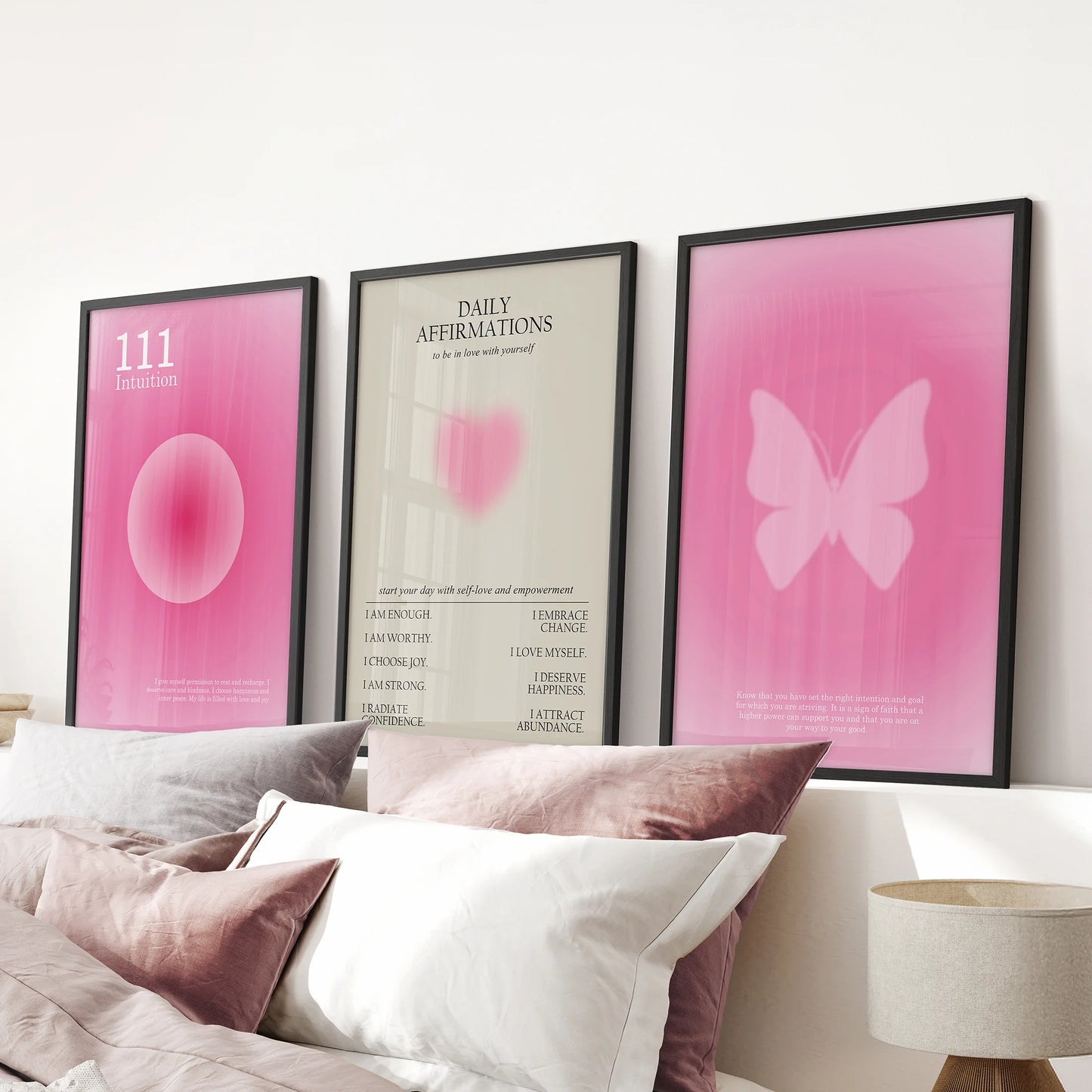 Motivational quote wall art in pink, set of 3 prints, rests over the bed in a pink bedroom with clean black-framed edges.