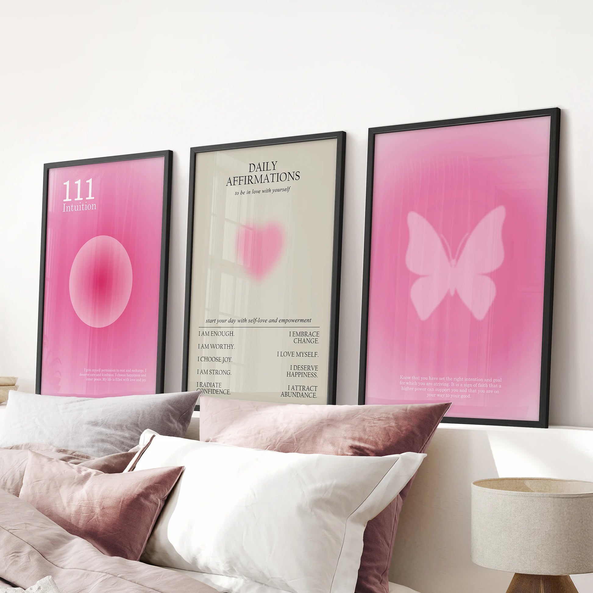 Motivational quote wall art in pink, set of 3 prints, rests over the bed in a pink bedroom with clean black-framed edges.