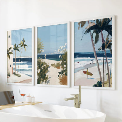 Set of three white-framed palm tree prints brightens the wall above the bathroom tub, adding a clean, coastal air to the space.