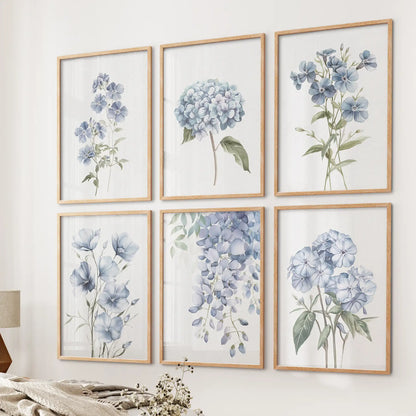 Botanical wall art set with watercolor blue flowers like hydrangeas and wisteria. Thinwood frames over the bed.