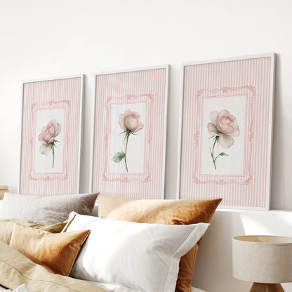 Three-piece floral bouquet wall art set in white frames, hanging above the bed in a bedroom.